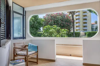 an open window in a room with a chair and a view of trees at Sunshine Apartment in Vilamoura