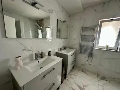 a white bathroom with a sink and a mirror at Casa Vila Real in Mem Moniz