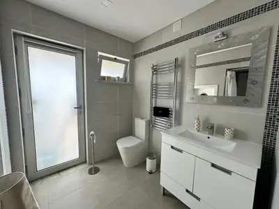 a bathroom with a sink and a toilet and a mirror at Casa Vila Real in Mem Moniz