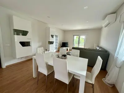 a white dining room with a white table and chairs at Casa Vila Real in Mem Moniz