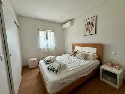 a bedroom with a large bed with white sheets at Casa Vila Real in Mem Moniz