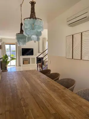 a dining room with a large wooden table and chairs at Algarve Boho Beach House in Albufeira