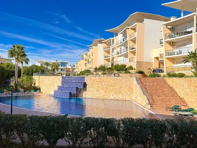 a swimming pool in front of some apartment buildings at Luxurious T2 with Pool & Breathtaking Ocean Views by BeCherish in Albufeira