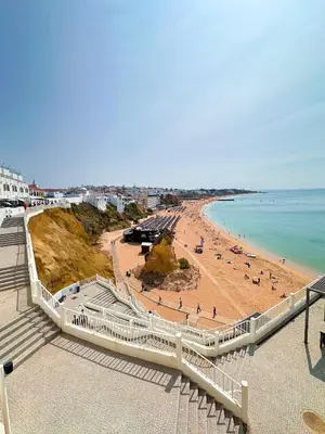a view of a beach with people on the sand at Luxurious T2 with Pool & Breathtaking Ocean Views by BeCherish in Albufeira