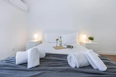 a bedroom with a large bed with towels on it at Alfamar Beach Apartment in Albufeira