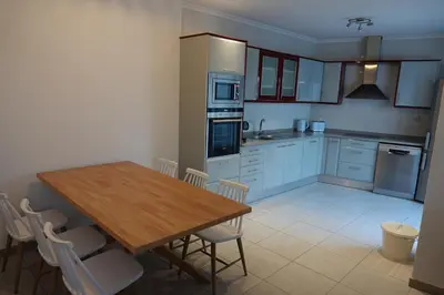 a kitchen with a wooden table and chairs in it at Blue House - City's Heart in Faro