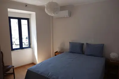 a bedroom with a blue bed and a window at Blue House - City's Heart in Faro
