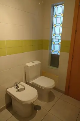 a bathroom with a toilet and a window at Blue House - City's Heart in Faro