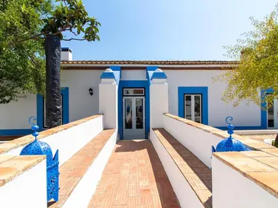 an exterior view of a house with blue doors at Casa Algarvia Senhorial by Stay ici Algarve Holiday Rental in Albufeira