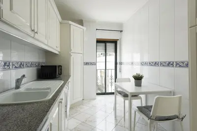 a kitchen with a sink and a table with chairs at Mango 2 - Faro City Center by HD in Faro