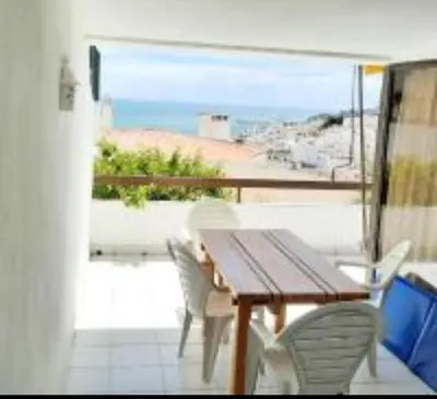 a table and chairs on a balcony with a view of the beach at Ocean view Cerro Branco with pool in Albufeira