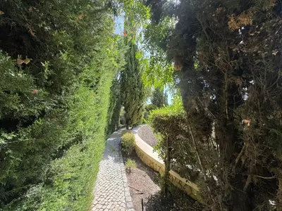 a stone path in a park with trees and bushes at Sunshine Villa em Vilamoura in Vilamoura