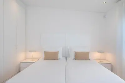 a bedroom with a large white bed with two lamps at Villa Cyan by SAPvillas in Vilamoura