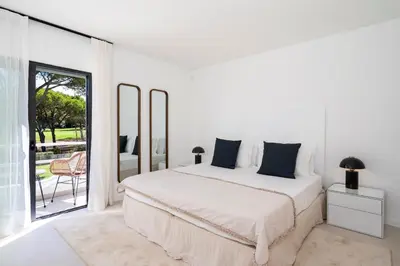 a white bedroom with a bed and a balcony at Villa Cyan by SAPvillas in Vilamoura