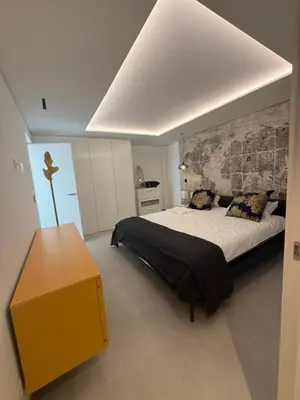 a bedroom with a large bed and a yellow table at Villa mar e Serra in Loulé