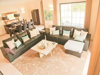 a living room with a couch and a table at Exceptional villa with swimming pool in Almancil