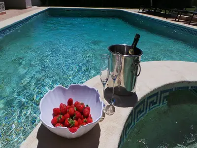 a bowl of strawberries sitting next to a swimming pool at Exceptional villa with swimming pool in Almancil