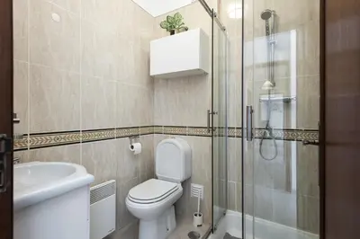 a bathroom with a toilet and a glass shower at Golfinho - Sea view with pool by HD in Quarteira
