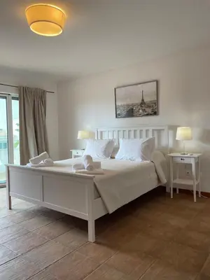a bedroom with a large white bed with white pillows at Casas da Corujeira Algarve in Albufeira