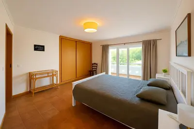 a bedroom with a large bed and a window at Casas da Corujeira Algarve in Albufeira
