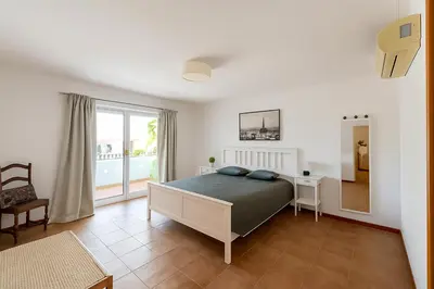a bedroom with a bed and a large window at Casas da Corujeira Algarve in Albufeira