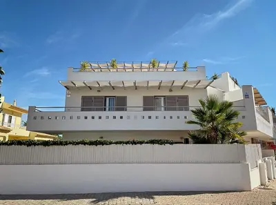 a white house with plants on the top of it at Casas da Corujeira Algarve in Albufeira