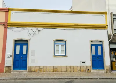 two blue doors on a white building at Casa Eliz Modern Comfort in the center of Faro in Faro