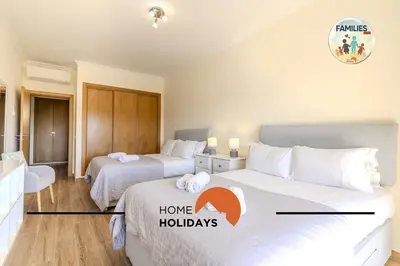 two beds in a hotel room with the words home holidays at #323 Jardins da Marina 2º BE by Home Holidays in Páteo
