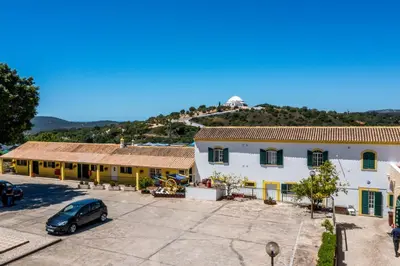 a building with a car parked in a parking lot at Quinta do Moinho in Loulé