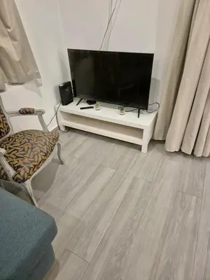 a living room with a flat screen tv on a white table at Beautiful View Apartment in Quarteira