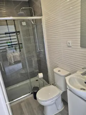 a bathroom with a toilet and a shower and a sink at Beautiful View Apartment in Quarteira