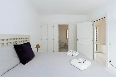 a white bedroom with a large bed with towels on it at Serenity Villa Vilamoura in Quarteira