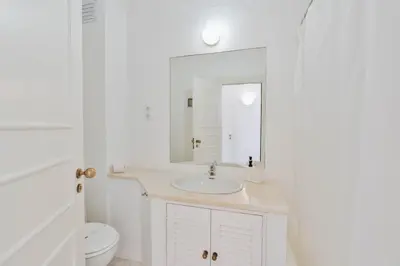 a white bathroom with a sink and a mirror at Serenity Villa Vilamoura in Quarteira