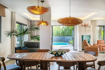 a living room with a wooden table and chairs at Stylish Algarve Retreat- Priv. Pool & Beach Nearby in Quarteira