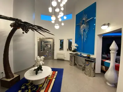 a living room with a palm tree in the middle of the room at Villa Karolina in Quarteira