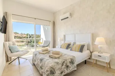 a bedroom with a bed and a chair and a window at #339 Albufeira Terras Novas N 4 By Home Holidays in Patroves
