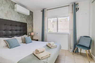 a bedroom with a bed and a chair and a window at #339 Albufeira Terras Novas N 4 By Home Holidays in Patroves