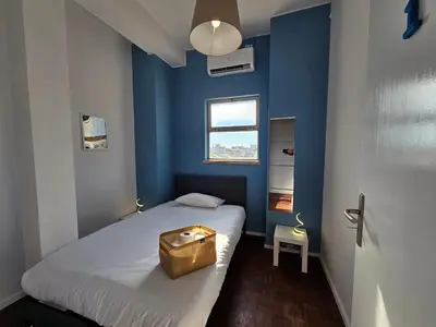 a blue bedroom with a bed with a bag on it at Blife Europya - private rooms at Santantonya 3rd floor in Faro