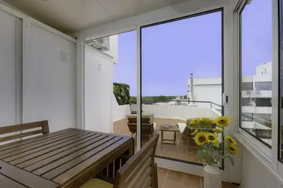 a balcony with a wooden bench and a table at GINGKO BILOBA ROOF TOP by My Algarve Rentals in Quarteira