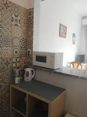a kitchen with a sink and a tile wall at Casa João Bravo in Albufeira