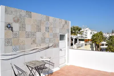 a balcony with chairs and a view of a city at Casa João Bravo in Albufeira