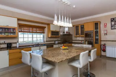 a kitchen with a large island with white bar stools at Luxury Villa with Private Pool, Gym & Leisure Room by Gale Beach LM25 in Guia