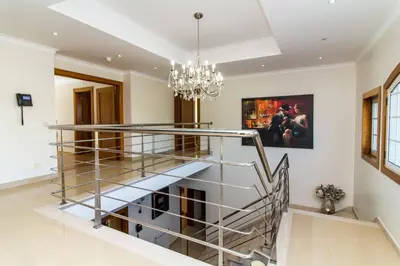 a spiral staircase in a living room with a chandelier at Luxury Villa with Private Pool, Gym & Leisure Room by Gale Beach LM25 in Guia