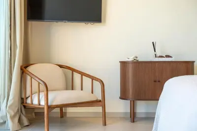 a chair sitting in a room next to a dresser at New Villa - Rooftop Jacuzzi & Sunset Views in Santa Bárbara de Nexe