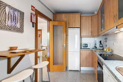 a kitchen with wooden cabinets and a white refrigerator at Do Vale Hollidays in Guia