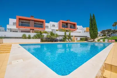 a villa with a swimming pool in front of a building at Galé by the Sea in Guia