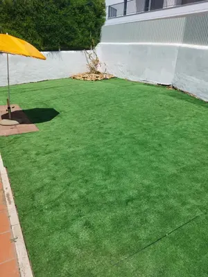 a lawn with a yellow umbrella on top of it at Jacaranda 43-Moradia terrea in Albufeira