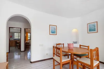 a kitchen with a table and a washing machine at Casa dos Bisos in Albufeira