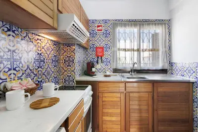 a kitchen with a wooden table and blue and white tiles at Casa dos Bisos in Albufeira