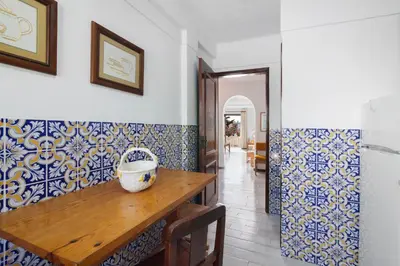 a hallway with a door and a table and chairs at Casa dos Bisos in Albufeira